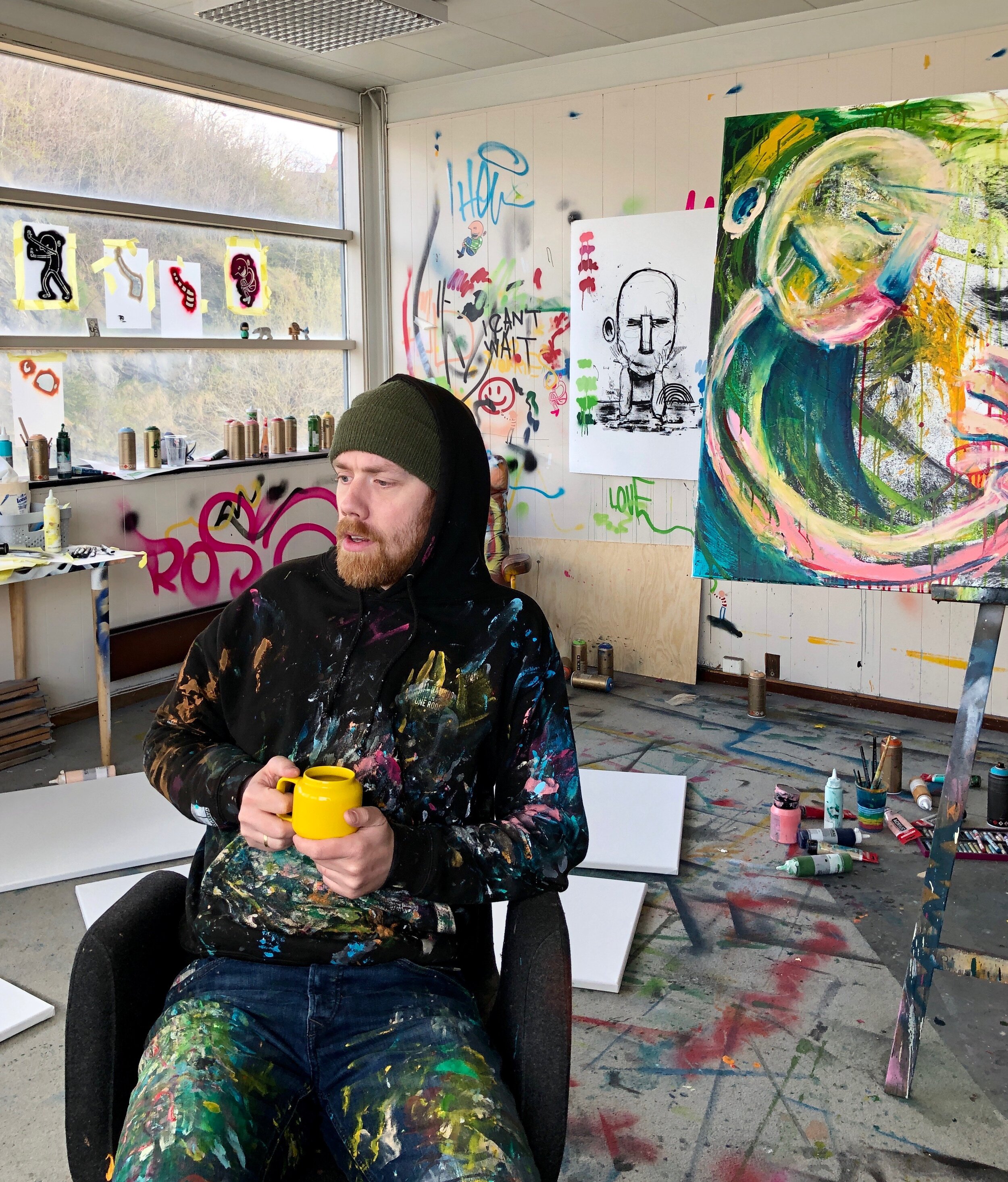 Ståle Gerhardsen sitter kunstnerstudio med kaffekopp i hånden. Foto